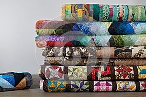 Quilts stacked on white wall background