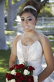 Quinceanera With Flower Bouquet In Lawn
