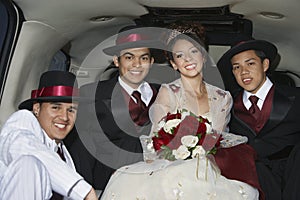 Quinceanera Sitting With Three Male Friends In Limousine