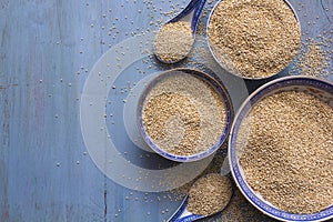 Quinoa in bowls on blue wooden table. Top view