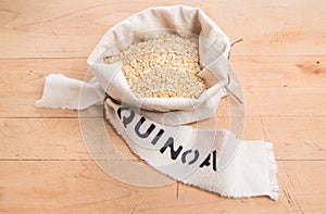 Quinoa flakes in a cream fabric bag with stencilled label