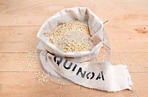 Quinoa flakes in a cream fabric bag with stencilled label