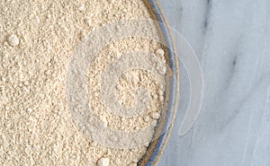 Quinoa flour in a bowl on a cutting board.