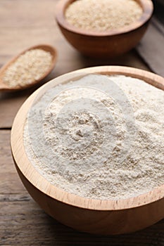 Quinoa flour in bowl on wooden table