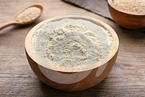 Quinoa flour in bowl on wooden table