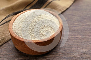 Quinoa flour in wooden bowl on wooden table