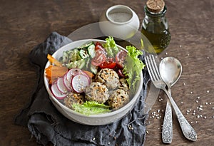 Quinoa meatballs and vegetable salad. Buddha bowl on a wooden table, top view. Healthy, diet, vegetarian food concept.