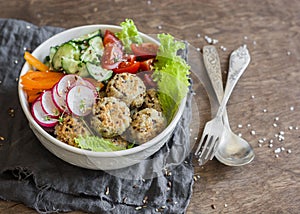 Quinoa meatballs and vegetable salad. Buddha bowl on a wooden table, top view. Healthy, diet, vegetarian food concept.