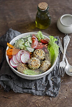 Quinoa meatballs and vegetable salad. Buddha bowl on a wooden table, top view. Healthy, diet, vegetarian food concept.