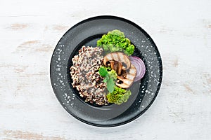 quinoa with mushrooms and vegetables on a plate. Top view.