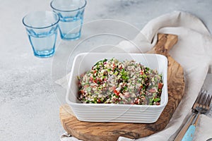 Quinoa Quinua salad with tomatoes and herbs in white bowl