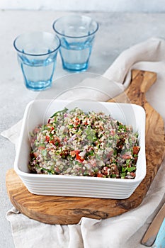 Quinoa Quinua salad with tomatoes and herbs in white bowl photo