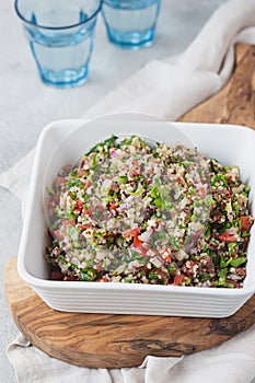 Quinoa Quinua salad with tomatoes and herbs in white bowl