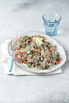 Quinoa Quinua salad with tomatoes and herbs in white bowl photo