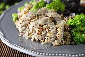 Quinoa salad with green pea,broccoli, olives. Healthy food, lunch over wooden background. Vegetarian food, snack