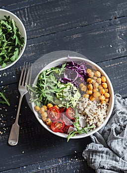 Quinoa and spicy chickpea vegetable vegetarian buddha bowl. Healthy food concept. On a dark background