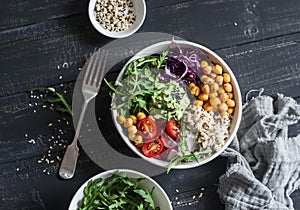 Quinoa and spicy chickpea vegetable vegetarian buddha bowl. Healthy food concept. On a dark background