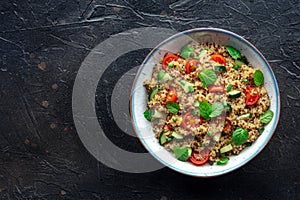 Quinoa tabbouleh salad in a bowl, a healthy dinner with tomatoes and mint