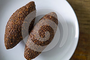 Quipe, delicioso kibbeh frito con salsa de yogur en un bol servido en un plato de arcilla sobre una vieja mesa de madera oscura, r photo