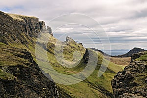 Quiraing, Isle of Skye, Scotland - Bizarre rocky landscape covered with green grass with two rocky cliffs in the foreground