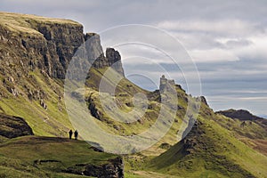 Quiraing, Isle of Skye, Scotland - Bizarre rocky landscape with two human figures standing on a cliff in the foreground photo