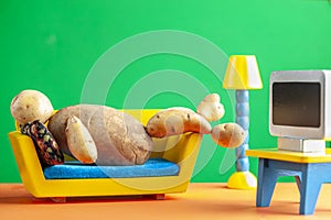 A quirky metaphorical concept image showing a potato man lying on a couch in a living room setting