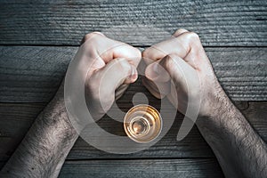 Quit Alcohol Drinking Concept With A Booze Glass Surrounded By 2 Stressed Looking Clenched Fists