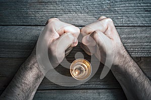 Quit Alcohol Drinking Concept With A Booze Glass Surrounded By 2 Stressed Looking Clenched Fists photo