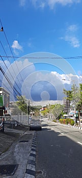 A quite street view in the middle of city with a cloudy sky.