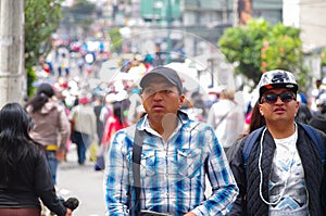 QUITO, ECUADOR - JULY 7, 2015: Two unidentified mens walking in the middle of the event, full of people. Pope Francisco