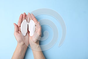 Quitting smoking concept. Woman holding paper lungs on light blue background, top view and space for text