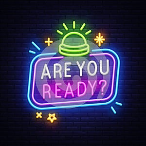 Quiz neon sign with buzzer and stars. Vector illustration with glowing button and text ARE YOU READY on dark wall photo