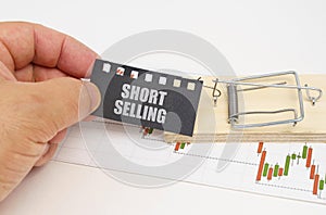 On the quote chart there is a mousetrap from which the hand takes out a sign with the inscription - Short Selling