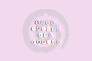 Quote Good things are coming made of round beads with multicolored letters.