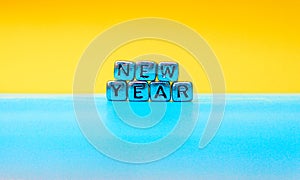 Quote made from mettle letters on yellow and blue background. Creative concept for new year greeting card