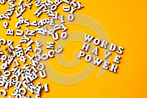 Quote WORDS HAVE POWER made out of wooden letters on bright yellow background photo