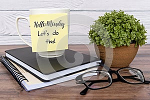 Quotes - Hello Monday, let`s do this text on sticky note on top of table photo
