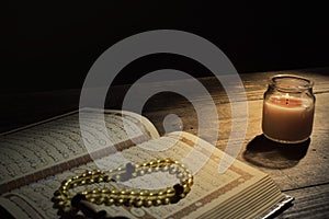 The Qur`an, the holy book of Islam. worship month of Ramadan, reading the scriptures by using a candle light.