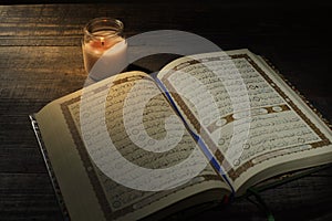 The Qur`an, the holy book of Islam. worship month of Ramadan, reading the scriptures by using a candle light.