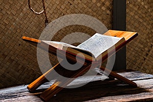 Quran on rihal or wooden book stand and misbaha or islamic prayer beads
