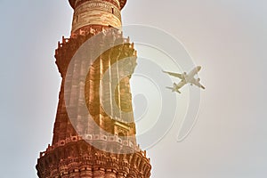 Qutb Minar minaret with airplane in sky background, tower part Qutb complex in South Delhi, India