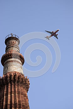 Qutb Minar tower and a plane, Delhi, India photo