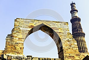Qutb Minar tower seen through the ruined Quwwat ul-Islam Mosque at Qutub Minar complex - New Delhi, India