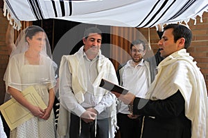 Rabbi blessing Jewish bride and a bridegroom in Jewish wedding c
