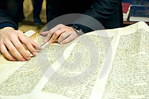 The rabbi`s hands are holding a Torah scroll. Torah reading
