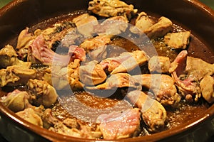 Rabbit and chicken meat frying in a clay pot