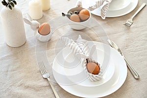 Rabbit Easter egg in napkin on plate. Easter dinner table setting concept