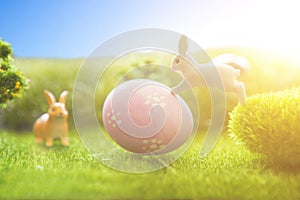 Rabbit and easter eggs in green grass with blue sky.