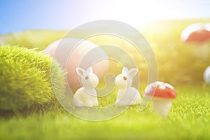 Rabbit and easter eggs in green grass with blue sky.