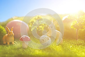 Rabbit and easter eggs in green grass with blue sky.